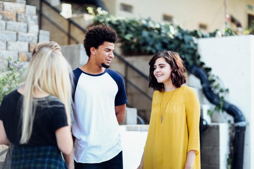 A group of young adults having a conversation outdoors.